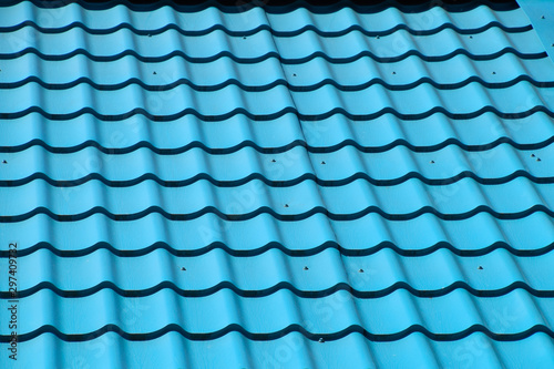 Turquoise metal tiles on roof of the house. Modern roofing materials