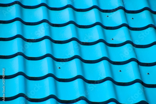 Turquoise metal tiles on roof of the house. Modern roofing materials