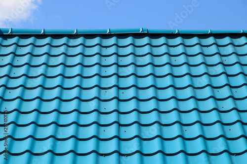 Turquoise metal tiles on roof of the house. Modern roofing materials