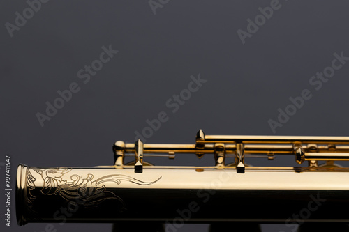 Fototapeta A shiny gold plated flute with an engraving on a reflective surface