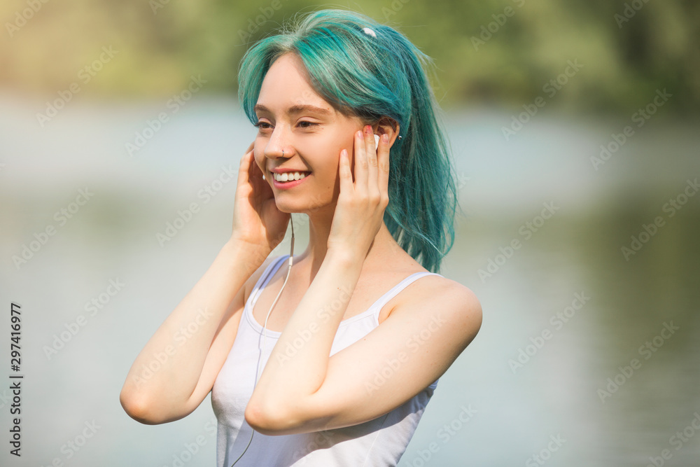 portrait of a beautiful young woman with green hair in a park in headphones portrait of a beautiful young woman with green hair in a park in headphones