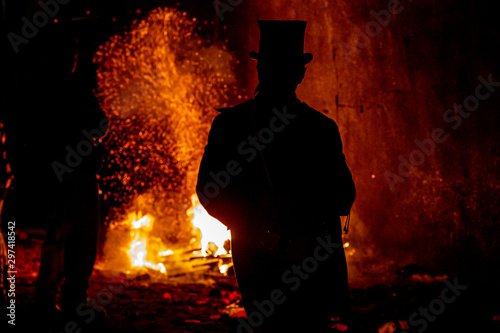 A silhouetted figure with flames behind, at Lewes bonfire night celebrations