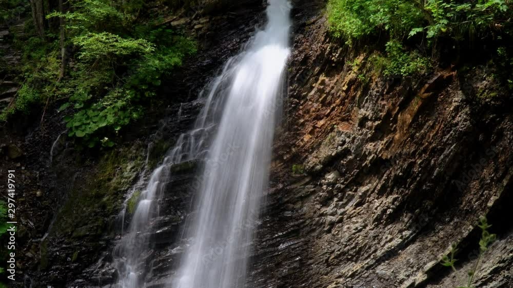 Beautiful waterfall in summer. A fast waterfall. View of the waterfall from below Beautiful waterfall in summer. A fast waterfall. View of the waterfall from below