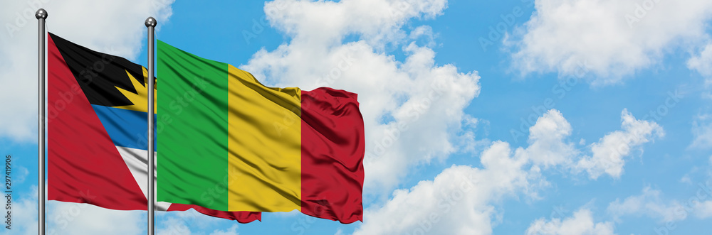 Antigua and Barbuda with Mali flag waving in the wind against white cloudy blue sky together. Diplomacy concept, international relations.