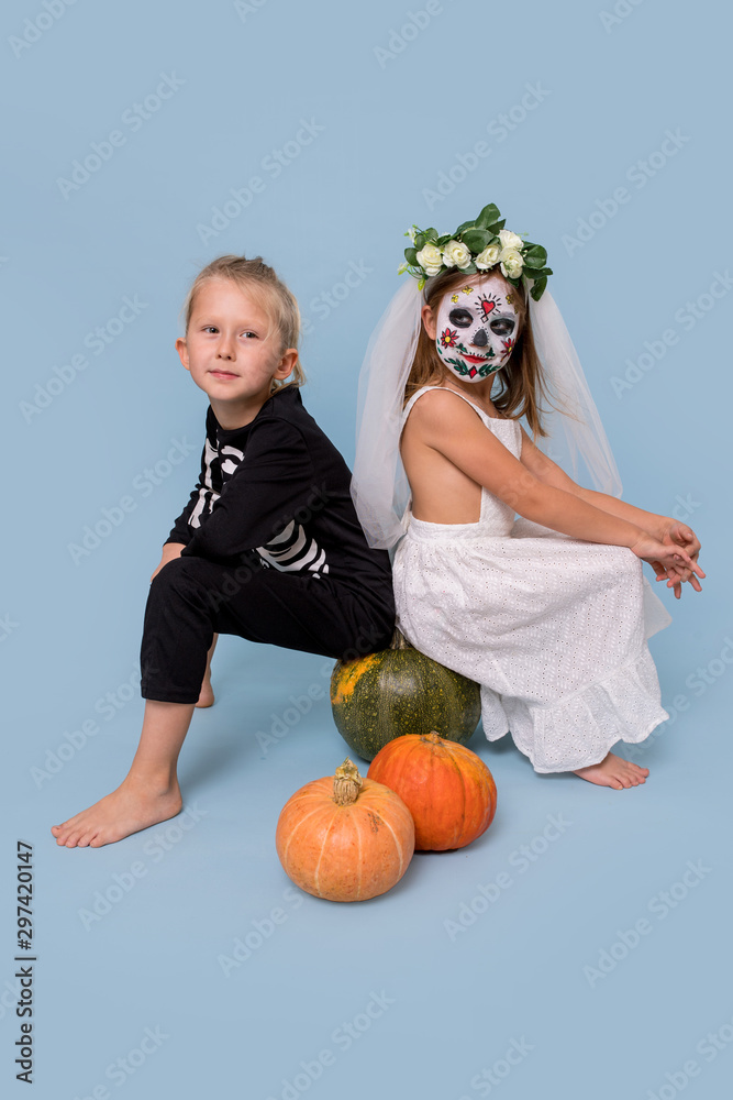 Fototapeta premium Children in a skeleton costume and a dead bride