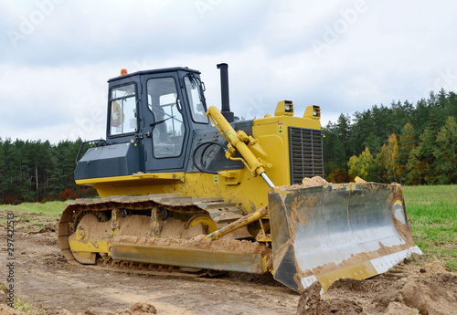 Track-type bulldozer  earth-moving equipment. Land clearing  grading  pool excavation  utility trenching  utility trenching and foundation digging during of large construction jobs.