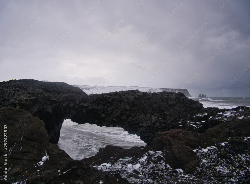 Blick durch ein Felsloch auf die Küste von Island