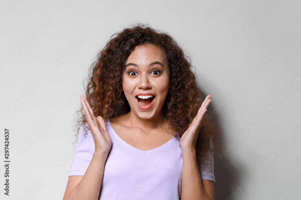Portrait of excited African-American woman on light background Portrait of excited African-American woman on light background