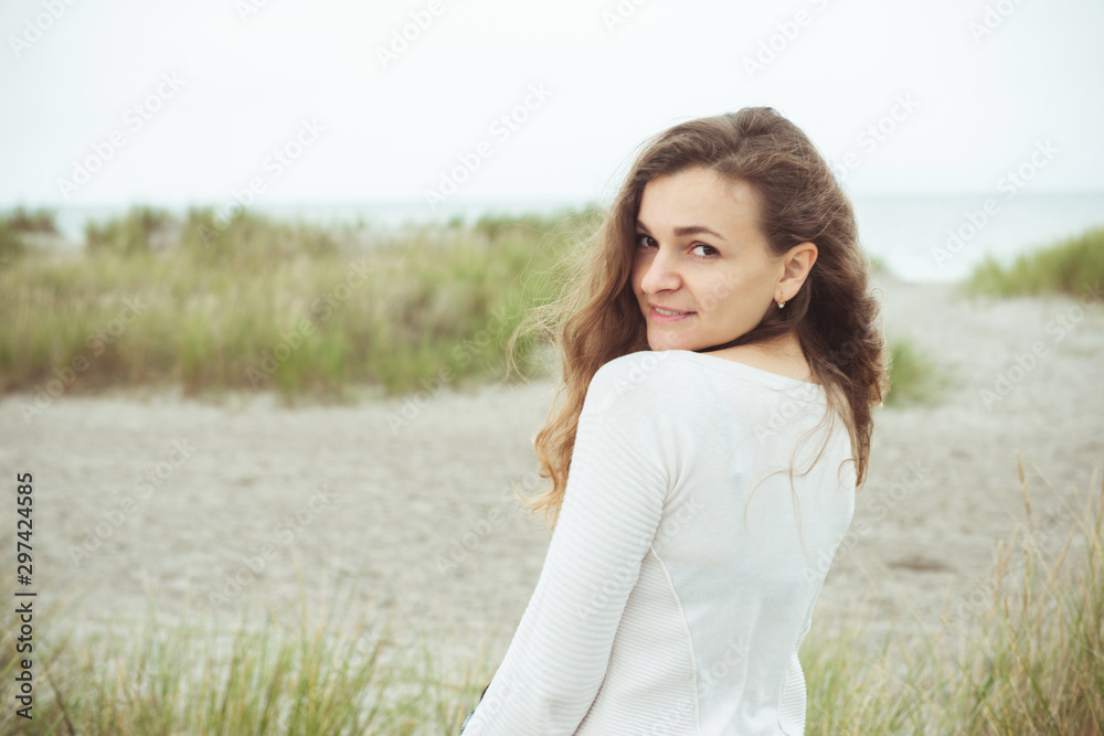 Portrait of pretty young woman posing on the Baltic sea beach in autumn Portrait of pretty young woman posing on the Baltic sea beach in autumn