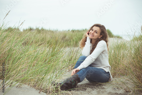 Portrait of pretty young woman posing on the Baltic sea beach in autumn