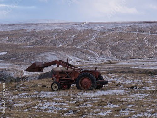 Ein alter Traktor mit Frontlader auf einer Wiese photo