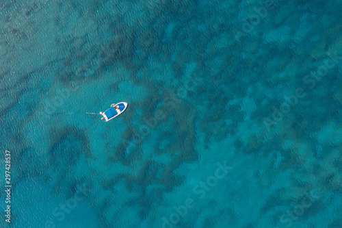 An aerial view of a boat the beautiful Mediterranean sea, where you can se the rocky textured underwater corals and the clean turquoise water of blue lagoon Agia Napa © Valentinos Loucaides