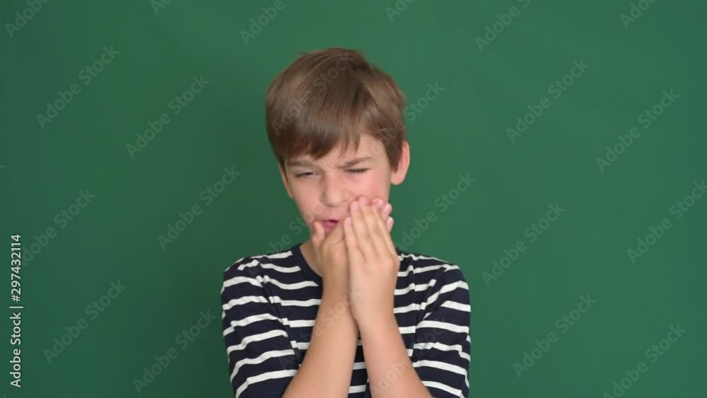 Young boy with toothache holding his cheek on the green screen Young boy with toothache holding his cheek on the green screen