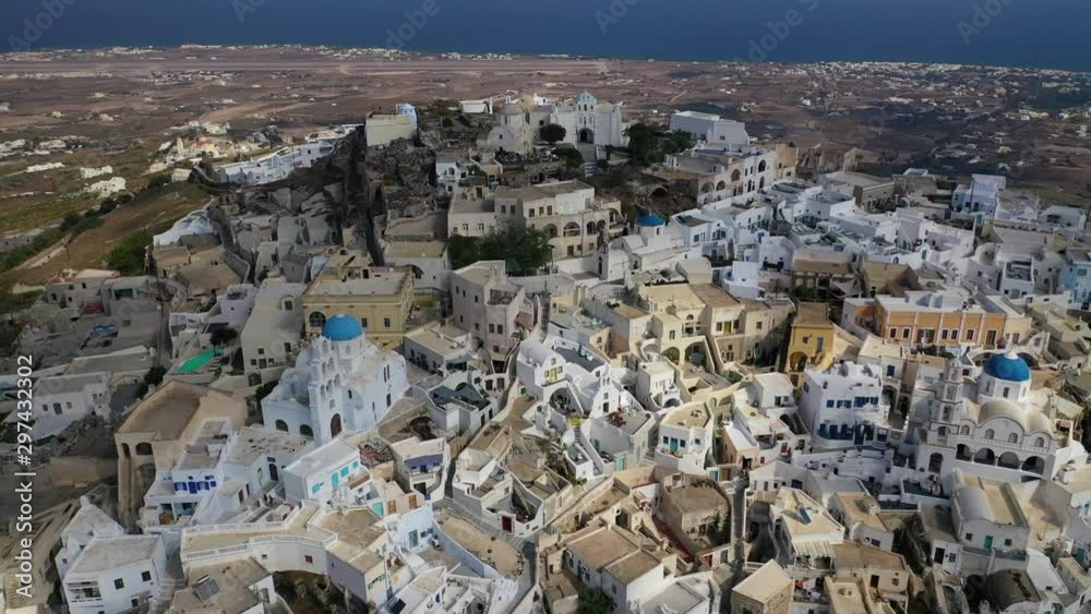 Aerial drone video of iconic small traditional village and uphill castle of Pyrgos with great views to Santorini island Cladera, Cyclades, Greece