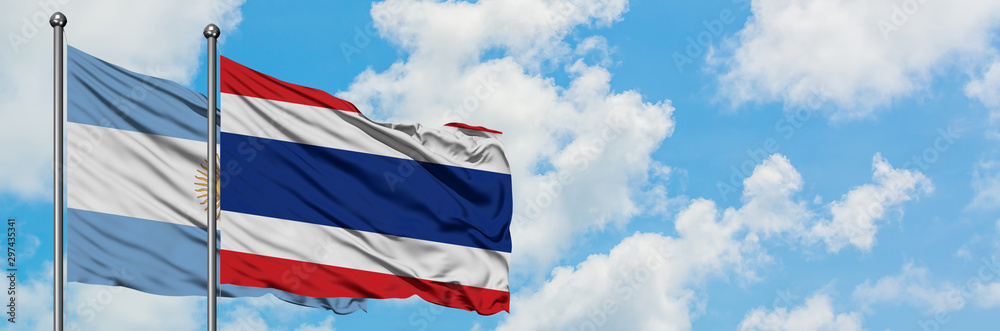 Naklejka premium Argentina and Thailand flag waving in the wind against white cloudy blue sky together. Diplomacy concept, international relations.