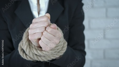 Office slavery. Female hands tied with a rope.
