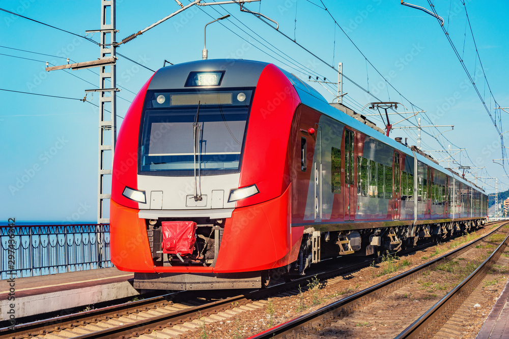 Passenger train stands along the platform by the Black sea coast. Sochi. Russia.