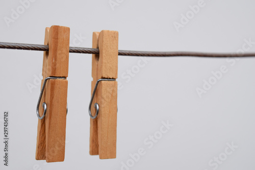 two wooden clothespins hanging on the clothesline
