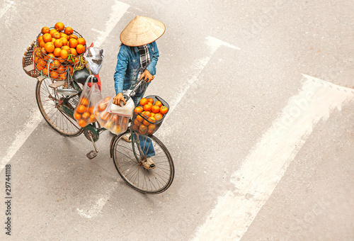 Peddler uses bicycles to carry oranges for sale around in Hanoi, Vietnam.