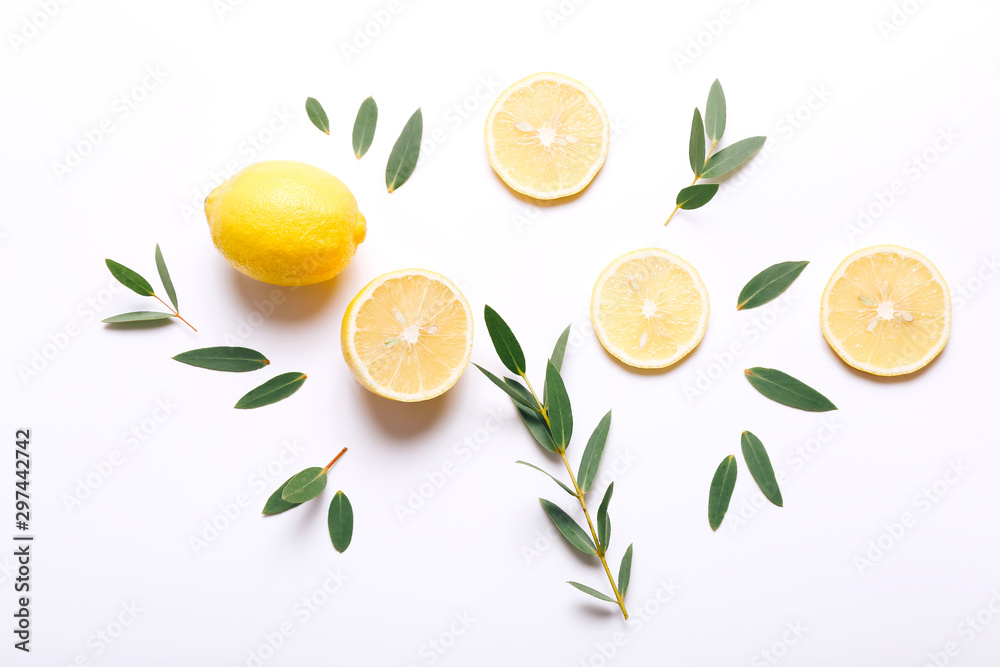 Fresh sliced lemon with green leaves on white background, top view