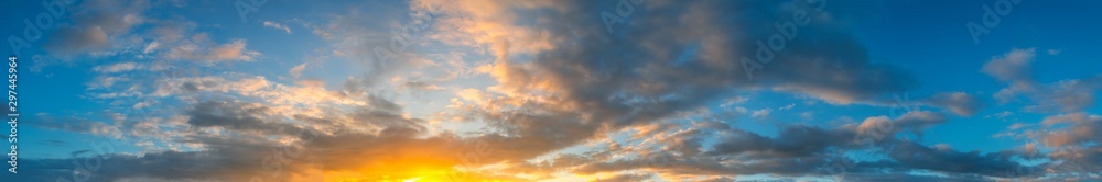 Panorama Sunlight with dramatic sky. Cumulus sunset clouds with sun setting down on dark background.Vivid orange cloud sky. Panorama Sunlight with dramatic sky. Cumulus sunset clouds with sun setting down on dark background.Vivid orange cloud sky.