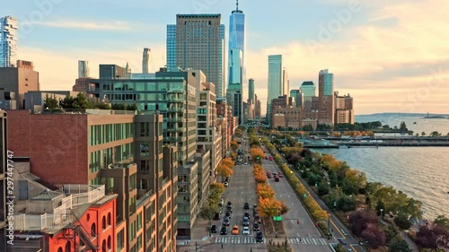 Drone footage with slow camera lift up along West Street in New York City on a sunny afternoon, before sunset