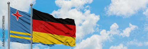 Aruba and Germany flag waving in the wind against white cloudy blue sky together. Diplomacy concept  international relations.
