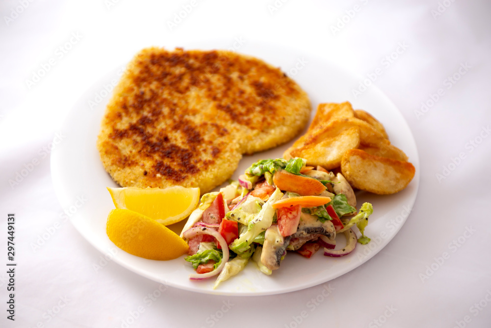 Heart shape Chicken Schnitzel with salad, fried potato wedges Heart shape Chicken Schnitzel with salad, fried potato wedges