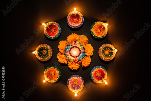 Happy Diwali - Clay Diya lamps lit during Dipavali, Hindu festival of lights celebration. Colorful traditional oil lamp diya on black background photo