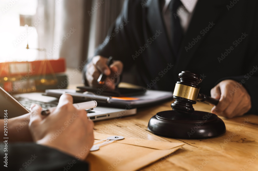 Business and lawyers discussing contract papers with brass scale on desk in office. Law, legal services, advice, justice and law concept . Business and lawyers discussing contract papers with brass scale on desk in office. Law, legal services, advice, justice and law concept .
