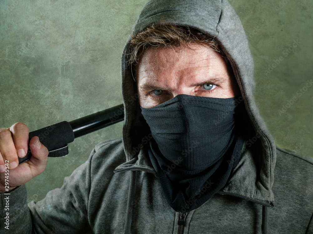 young man as fanatic and aggressive ultra anarchist rioter . furious  anti-system protester in face mask holding baton looking hostile fighting  at violent riot Stock Photo | Adobe Stock