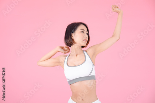 sport woman standing open hands and showing muscle bodybuilding on pink backgrounds, fitness concept, sport concept