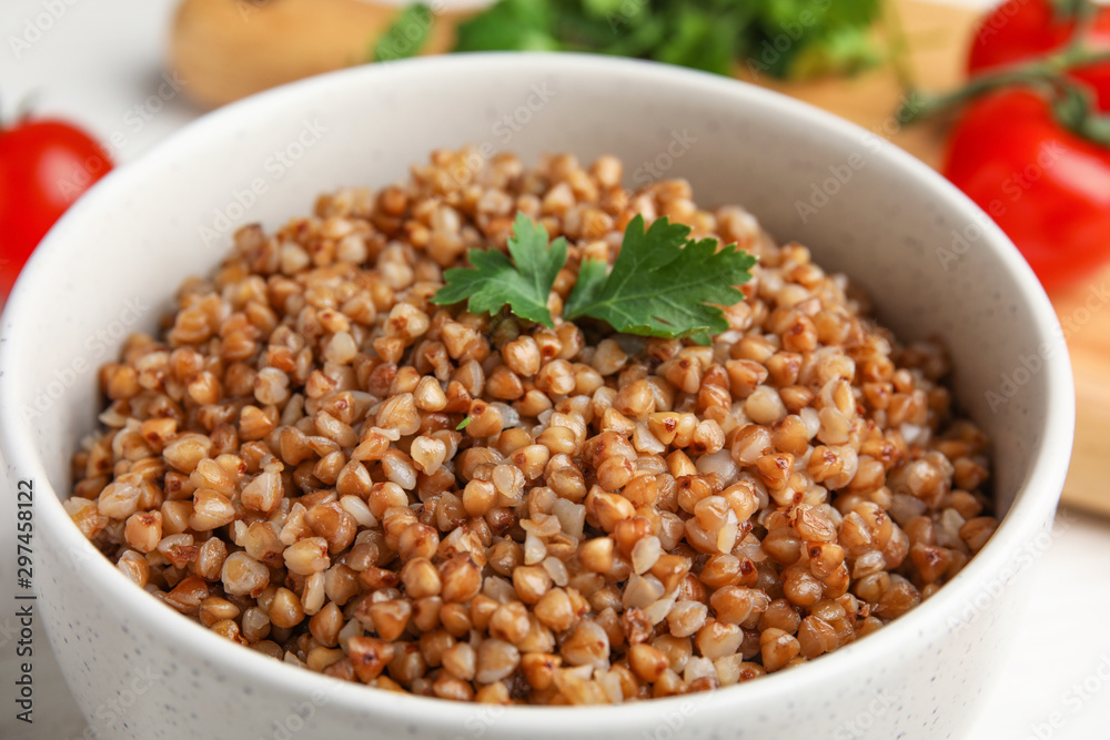 Bowl of buckwheat porridge with parsley on table, closeup Bowl of buckwheat porridge with parsley on table, closeup
