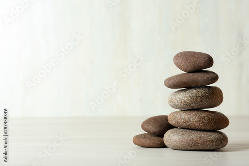Stack of spa stones on table against white background  space for text