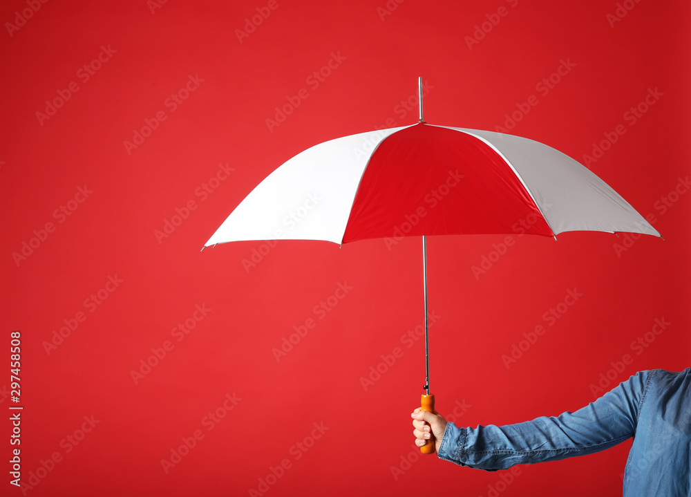Woman holding modern colorful umbrella on red background, closeup. Space for text