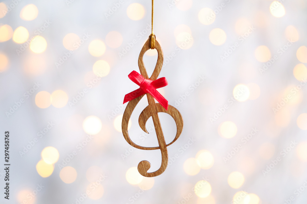 Wooden treble clef against blurred lights. Christmas music - obrazy, fototapety, plakaty 