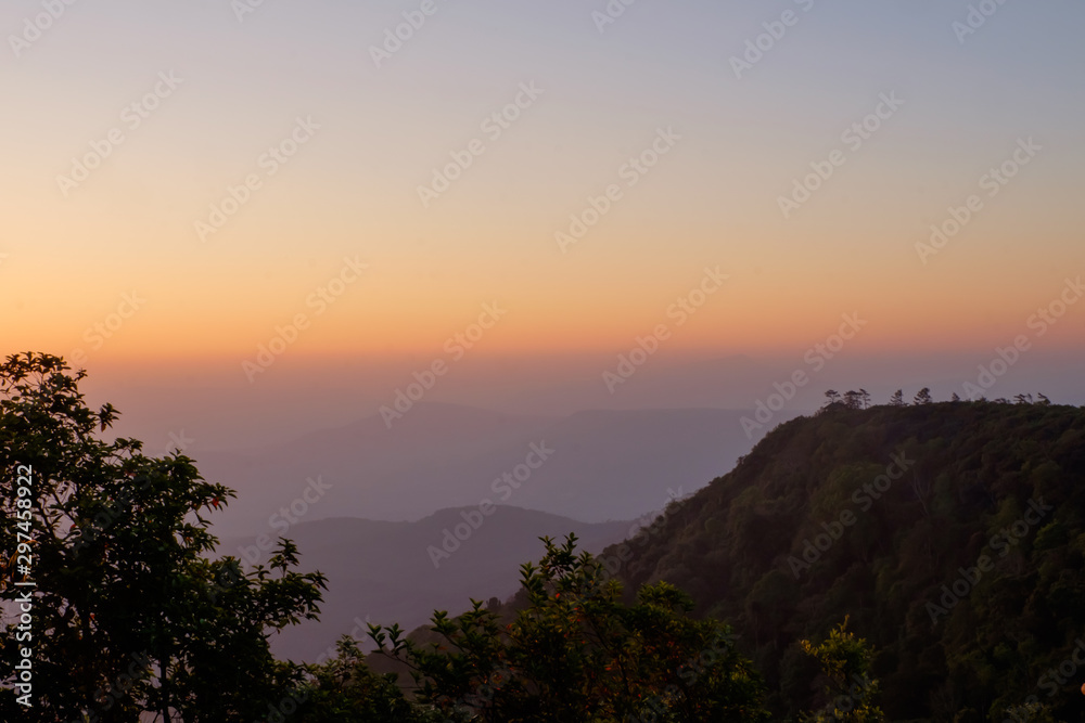 Sunrise View Point at Phu Ruea National Park, Loei, Thailand, orange and blue sky background with mist, morning light and nature freshness.-silhouette concept.