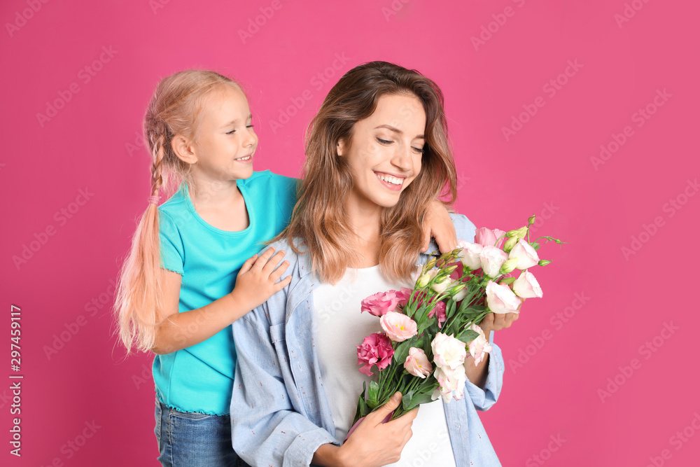Little daughter congratulating her mom on pink background. Happy Mother's Day