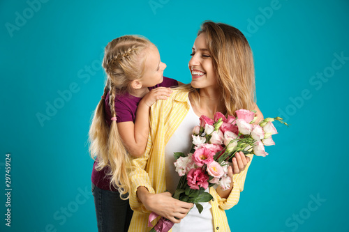 Little daughter congratulating her mom on blue background. Happy Mother's Day