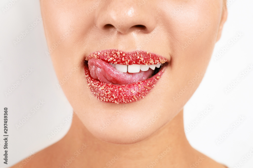 Obraz premium Young woman with sugar lips on white background, closeup