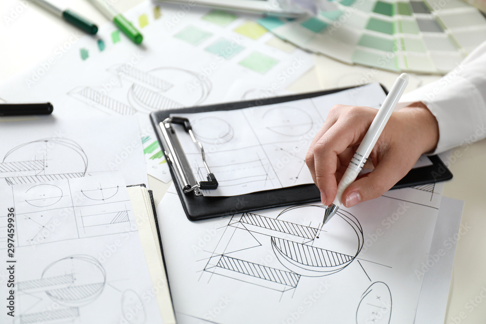 Female designer working at wooden table, closeup Female designer working at wooden table, closeup