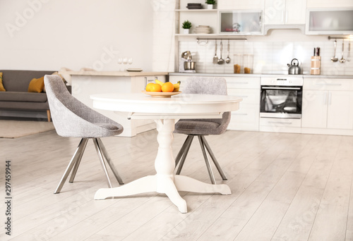 Stylish room interior with dining table and chairs