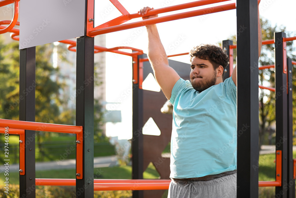 Obraz premium Young overweight man training on sports ground