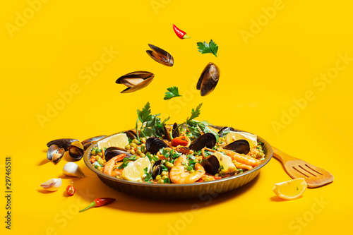 pan with spanish paella with seafood on a yellow background photo