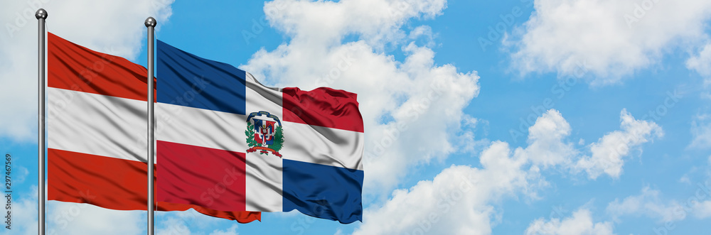 Fototapeta premium Austria and Dominican Republic flag waving in the wind against white cloudy blue sky together. Diplomacy concept, international relations.