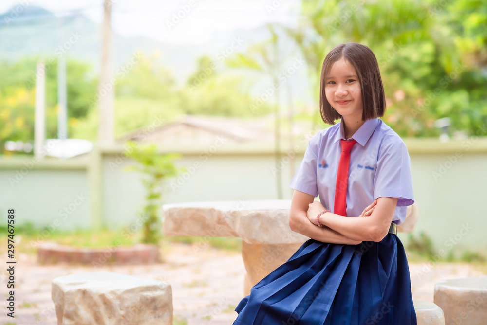 The smiling Asian high school female student in white uniform is smiling. The smiling Asian high school female student in white uniform is smiling.
