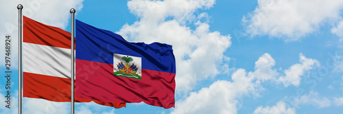 Obraz na płótnie Austria and Haiti flag waving in the wind against white cloudy blue sky together