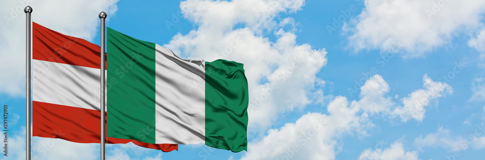 Austria and Nigeria flag waving in the wind against white cloudy blue sky together. Diplomacy concept, international relations. Austria and Nigeria flag waving in the wind against white cloudy blue sky together. Diplomacy concept, international relations.
