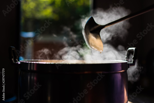 Fotografía Cooking person in the restaurant is cooking while using the dipper in a large pot