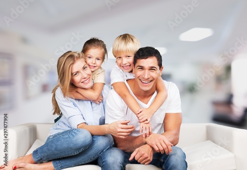 Beautiful smiling family sitting at sofa at home